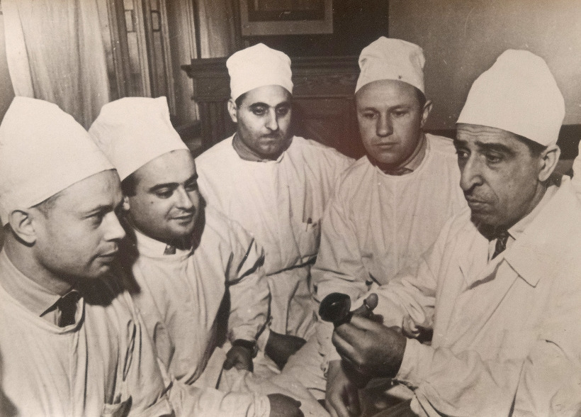 Каро Овнатанян (крайний справа) демонстрирует специальный зажим,
применяемый при операциях опухоли мочевого пузыря